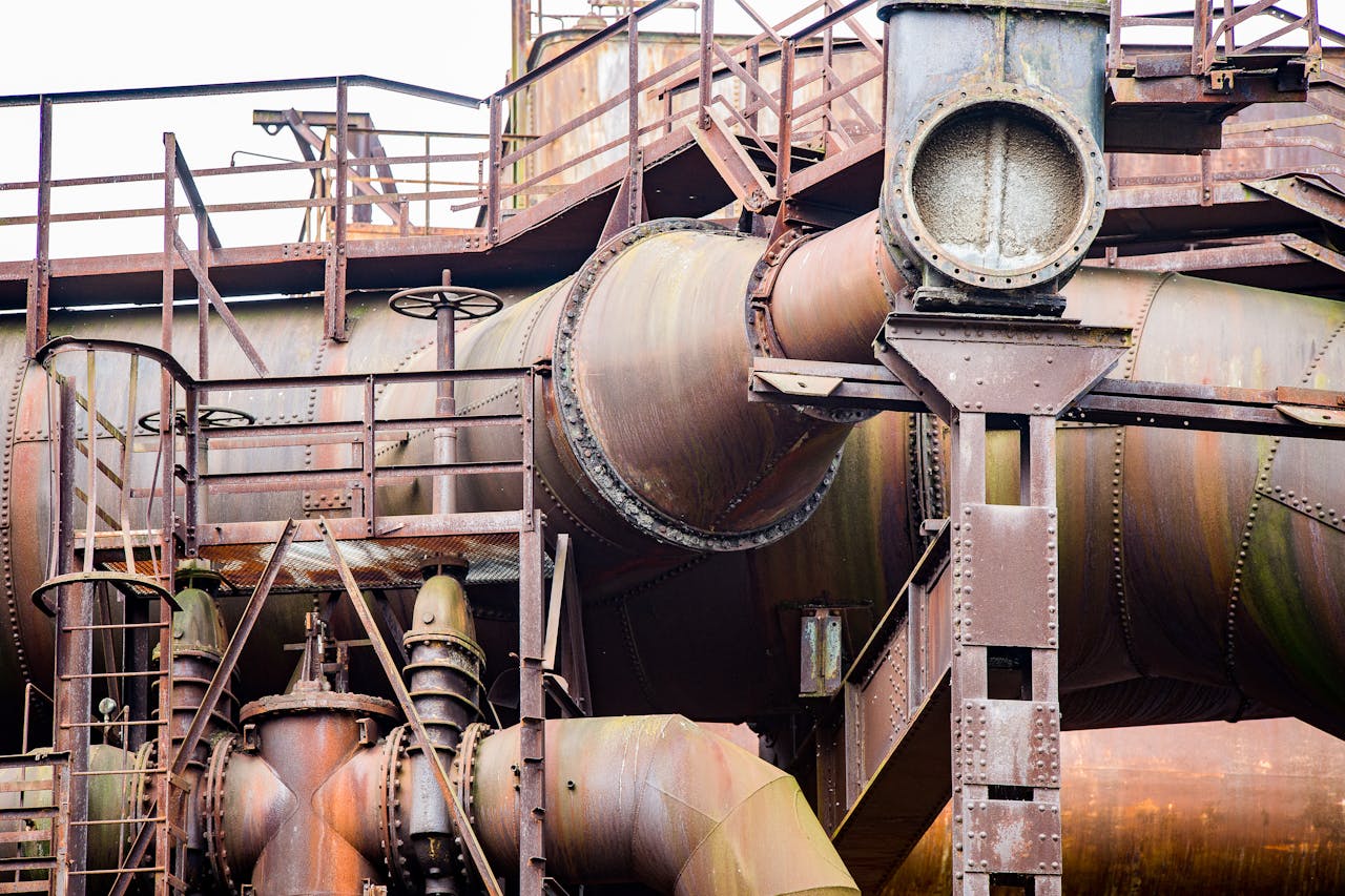 Detailed view of a rusty industrial pipe system showcasing robust metal construction and aged textures.